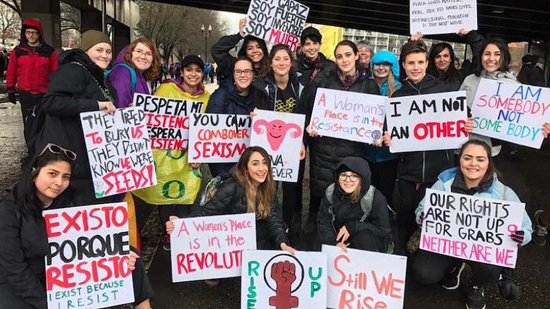 Kiva Hanson and fellow activists speak out in support of women’s rights. Group photo of students holding signs in support of women's rights.