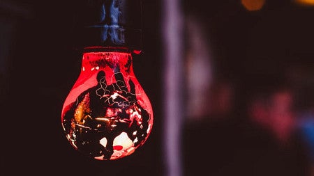A colorful lit red light bulb