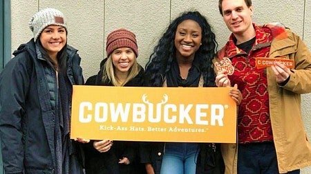 Allen Hall public relations students holding Cowbucker sign