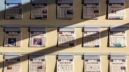 Past editions of the News & Herald displayed on a wall.