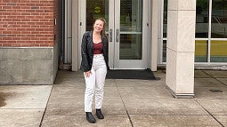 Erin Tooley stands in front of Allen Hall on the University of Oregon campus