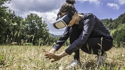 person wearing VR headset in a field