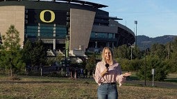 A woman speaking into a microphone outside of Autzen Stadium.