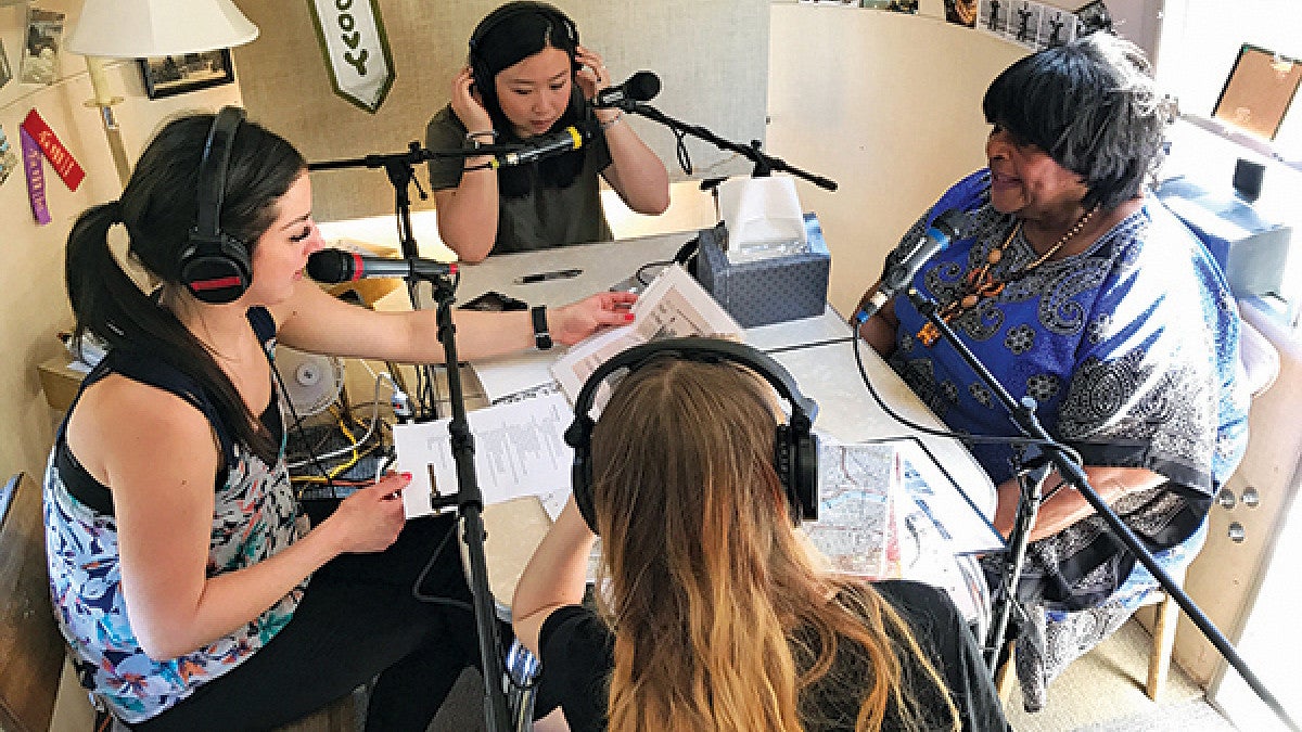 Students sitting a table recording an interview with a resident of Vanport Students sitting a table recording an interview with a resident of Vanport