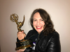 Beth Maiman smiles at the camera while holding the Sports Emmy Award she received in 2017.